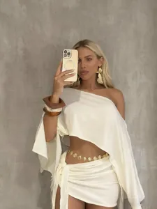 Elegante completo due pezzi bianco con top monospalla e minigonna a portafoglio