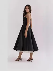 Elegante vestido midi negro sin mangas con tirantes finos y falda de tul blanco con capas