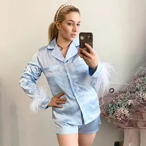 Vue détaillée de l'ensemble pyjama en satin bleu clair avec plumes sur le modèle