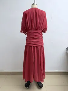 Rückansicht eines burgunderroten plissierten Maxikleides auf einer Mannequin für den Strand