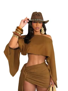 Dettaglio del set vacanza marrone da donna con top scoperto e gonna a portafoglio e cappello.
