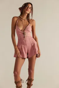 Close-up detail of a pink denim romper with a deep V-neck and stylish halter strap design