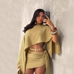 Ensemble chic olive avec haut asymétrique et mini-jupe pour les vacances à la plage.
