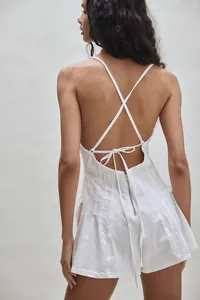 Close-up back view of a white denim romper featuring cross-straps and a zipper closure