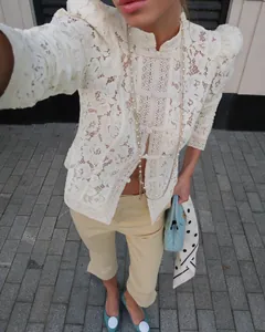 Elegant white lace crocheted stand-collar blouse featured in a chic street style outfit