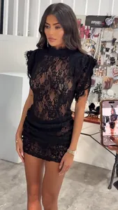 Detailansicht eines sexy schwarzen Spitzenminikleids mit Stehkragen und Rüschen