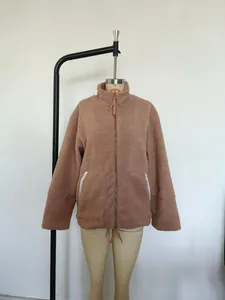 Detailweergave van een warme bruine sherpa fleece jas met hoge kraag en ritssluiting