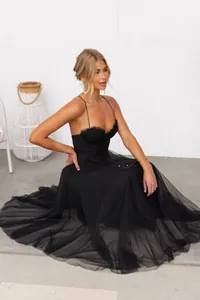Elegant black tulle evening dress with thin spaghetti straps and ruffled sweetheart neckline.