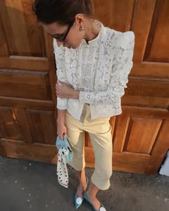 Elegant white lace crochet stand-up collar shirt shown in a chic outdoor setting