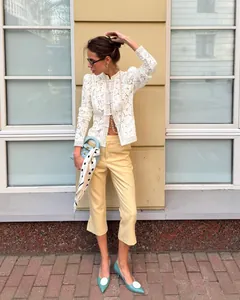 Elegant white lace crochet blouse with stand collar and long sleeves worn by a model