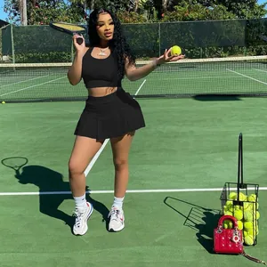 Ensemble de sport deux pièces avec débardeur noir et jupe de tennis plissée sur court.