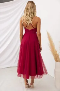 Detail of maroon evening dress featuring cross-back straps and layered tulle skirt