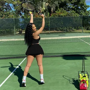 Ensemble deux pièces mode débardeur sport noir et jupe plissée sur court de tennis