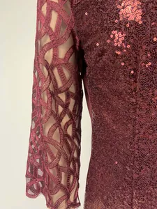Close-up detail of burgundy sequin evening dress with intricate mesh patchwork sleeves