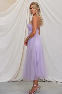 Detailed side view of an elegant purple tulle spaghetti strap evening maxi dress on a model