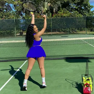 Ensemble de tennis deux pièces bleu vif porté par un modèle sur un court extérieur