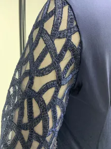 Detail of navy blue slim party dress featuring sparkly mesh patchwork sleeve design.