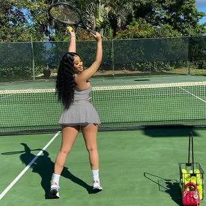 Ensemble de sport deux pièces gris avec débardeur et jupe-short pour femme sur un court de tennis
