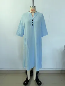 Detail van lichtblauwe katoen-linnen midi-jurk met V-hals en knoopsluiting