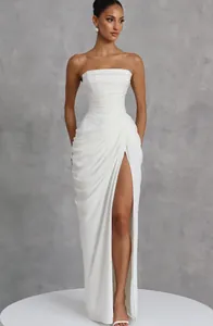 Elegante vestido largo blanco palabra de honor con pliegues y una abertura lateral alta.