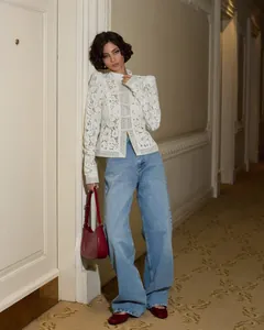 Detailed view of elegant white lace crochet long-sleeve shirt with stand-up collar