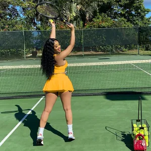 Mannequin portant une tenue de tennis orange deux pièces avec débardeur et jupe