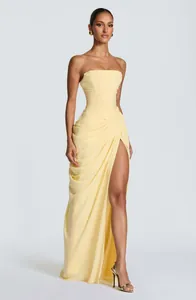 Detailed view of elegant strapless pleated maxi dress with high slit in light yellow.