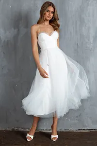 Detailed view of elegant white tulle evening dress with corset bodice and mesh skirt.