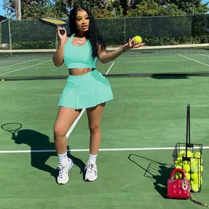 Vue d'ensemble d'un ensemble de sport vert menthe avec jupe plissée sur court de tennis