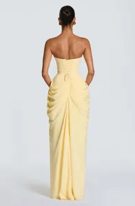 Back view detail of elegant yellow strapless dress with corset lace-up and pleats.