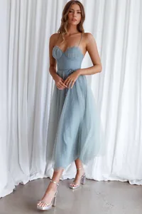 Elegant detail view of a light blue mesh evening dress featuring a ruffled bodice.