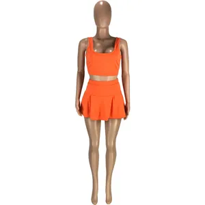 Vue de face de l'ensemble de sport deux pièces orange avec débardeur et jupe-culotte plissée