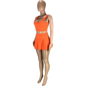 Vue latérale de l'ensemble de sport orange avec haut court et jupe-short plissée