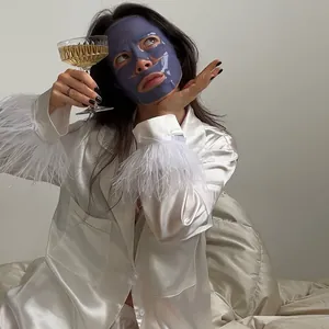 Élégant ensemble de pyjama en soie blanche avec des poignets en plumes luxueuses.