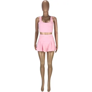 Ensemble sport deux pièces rose avec débardeur ajusté et jupe-culotte plissée sur mannequin