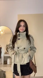 Model wearing a vintage khaki short trench coat with double-breasted belt detail