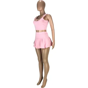Vue latérale d'un ensemble de sport rose deux pièces avec crop top et jupe plissée