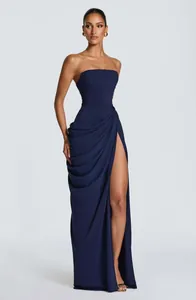 Close-up of navy blue strapless dress with asymmetric draping and a high leg slit