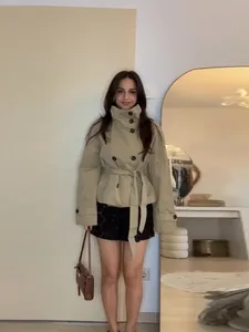 Stylish khaki double-breasted short trench coat with a waist belt for women.