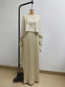 Detailed view of an elegant cream pleated two-piece set featuring a cape top and maxi skirt