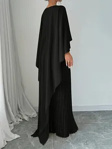Side view of elegant black pleated two-piece set featuring batwing sleeves and irregular hem