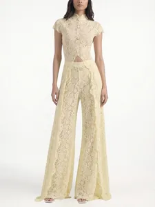 Full body view of an elegant pale yellow lace jumpsuit featuring a waist cutout and wide-leg design
