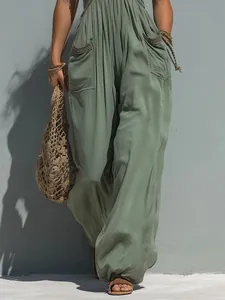 Detalle de cerca del mono verde salvia con pierna ancha y bolsillos de estilo bohemio