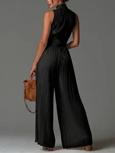 Back view of black pleated halter jumpsuit with wide legs and flowing texture