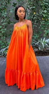 Full-length lifestyle view of a vibrant orange spaghetti strap maxi dress on a fashion model