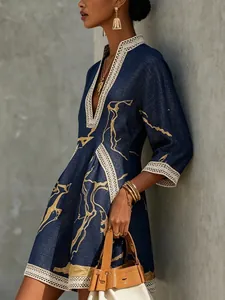Detailed view of navy blue cotton linen dress with gold abstract print and lace trim