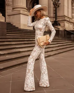Elegante witte jumpsuit van bloemenkant met lange mouwen en hoge kraag detail