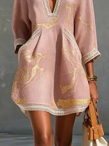 Detail of pink linen dress with gold abstract print and lace trim accents