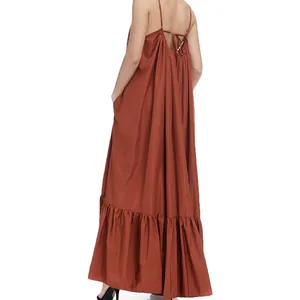 Rear view of loose rust-colored spaghetti strap maxi dress with tiered ruffled hem