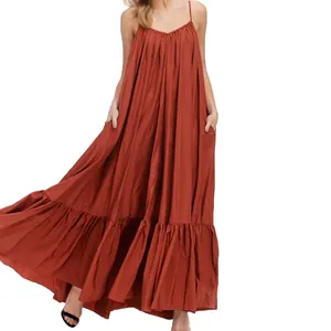 Close-up detail of the flowing tiered hem on this elegant rust-red sleeveless maxi dress